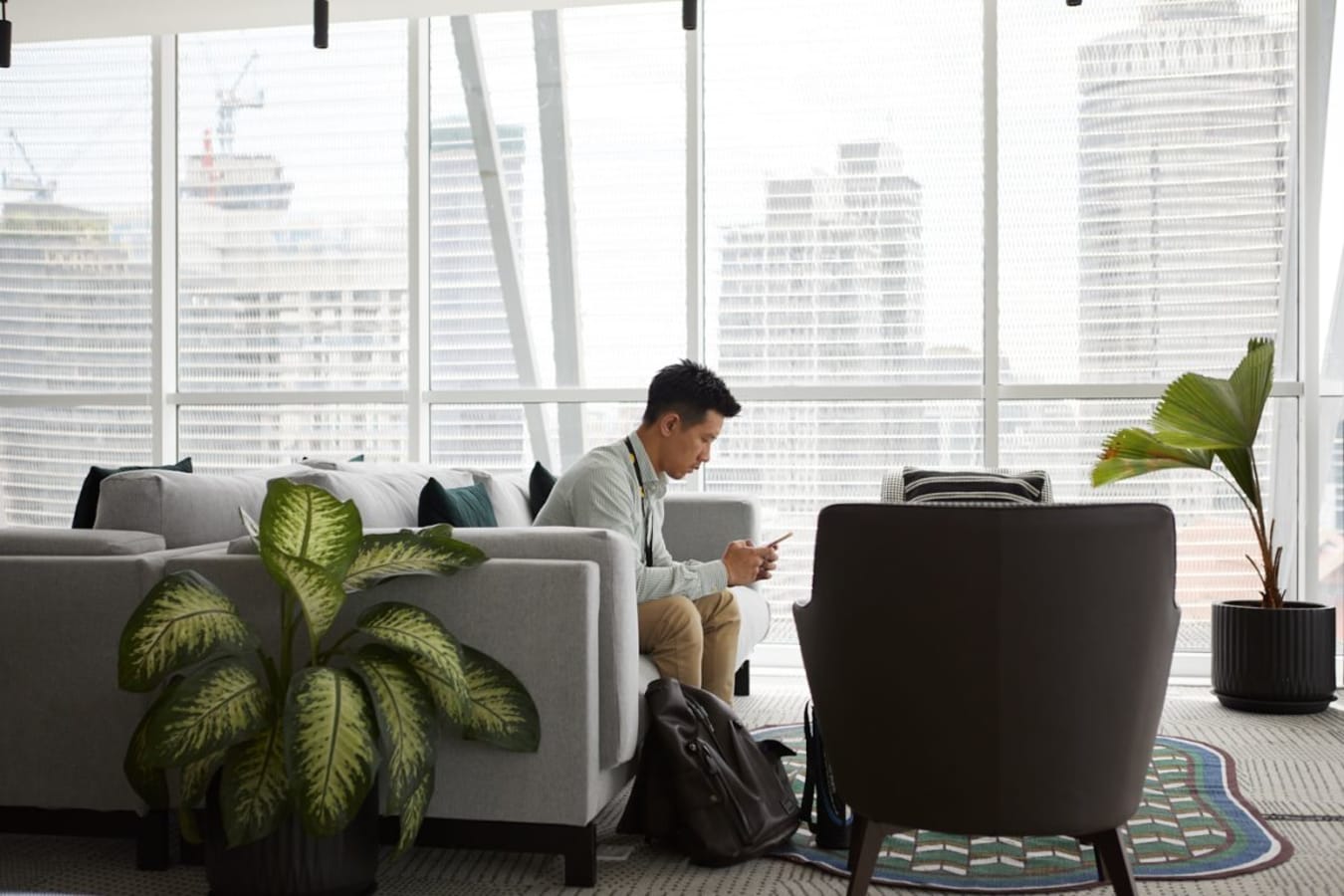Stylish coworking space with city views, lush plants, and comfy seating. Ideal for productivity.