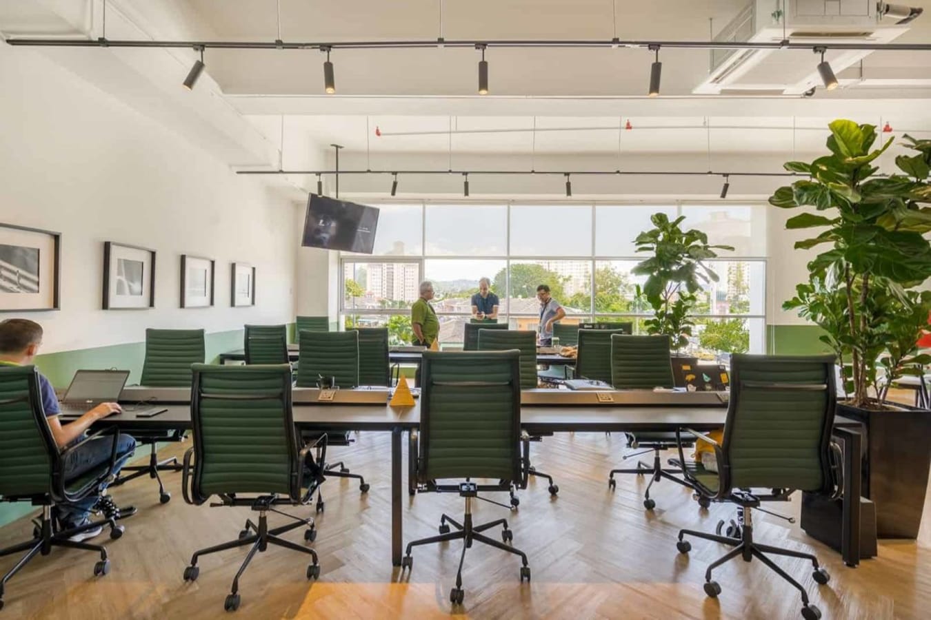 Bright, open coworking area with stylish chairs and greenery. Ideal for collaboration and focus.