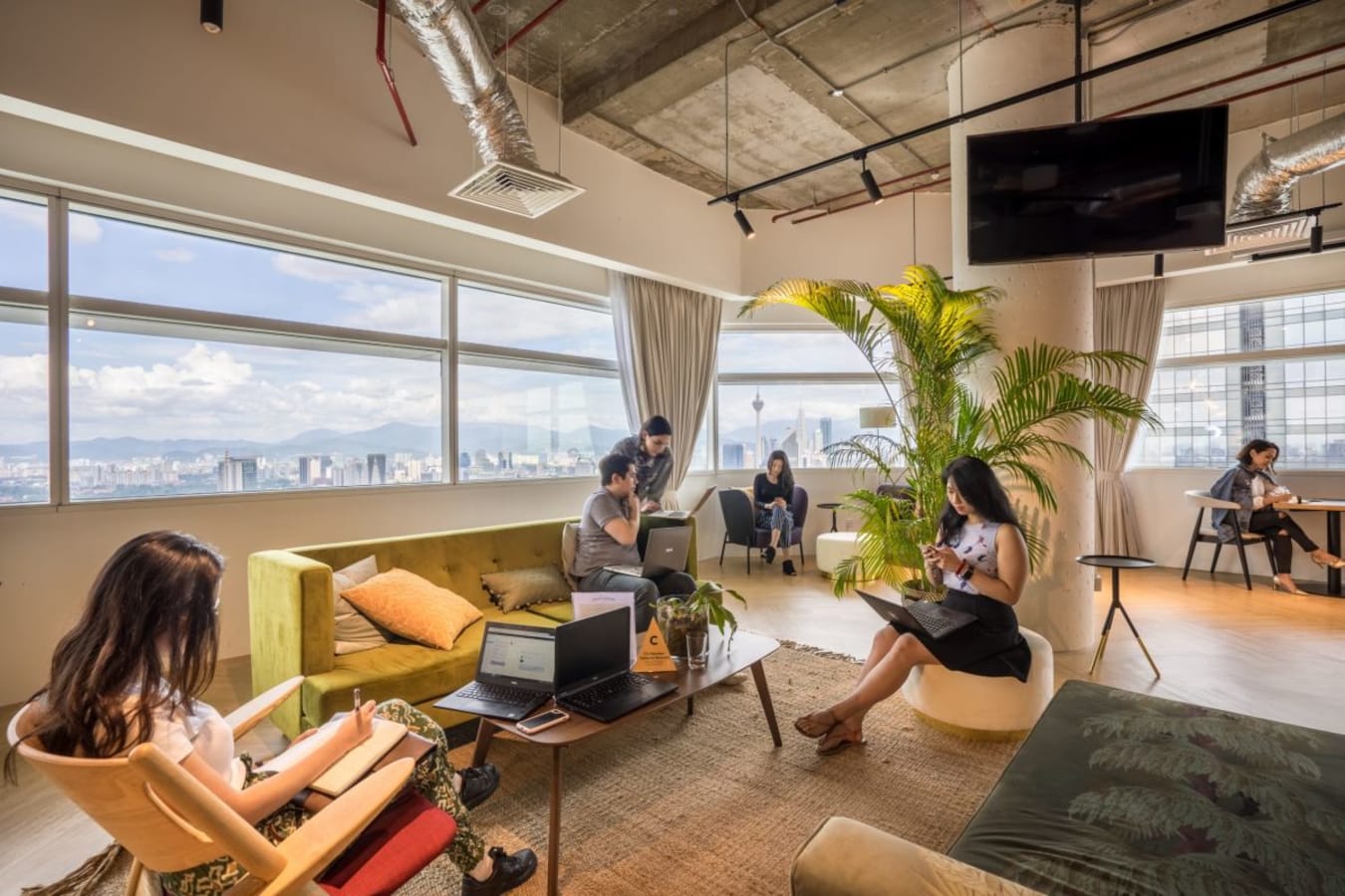 Bright coworking space with city views, modern seating, and relaxed atmosphere in Kuala Lumpur.