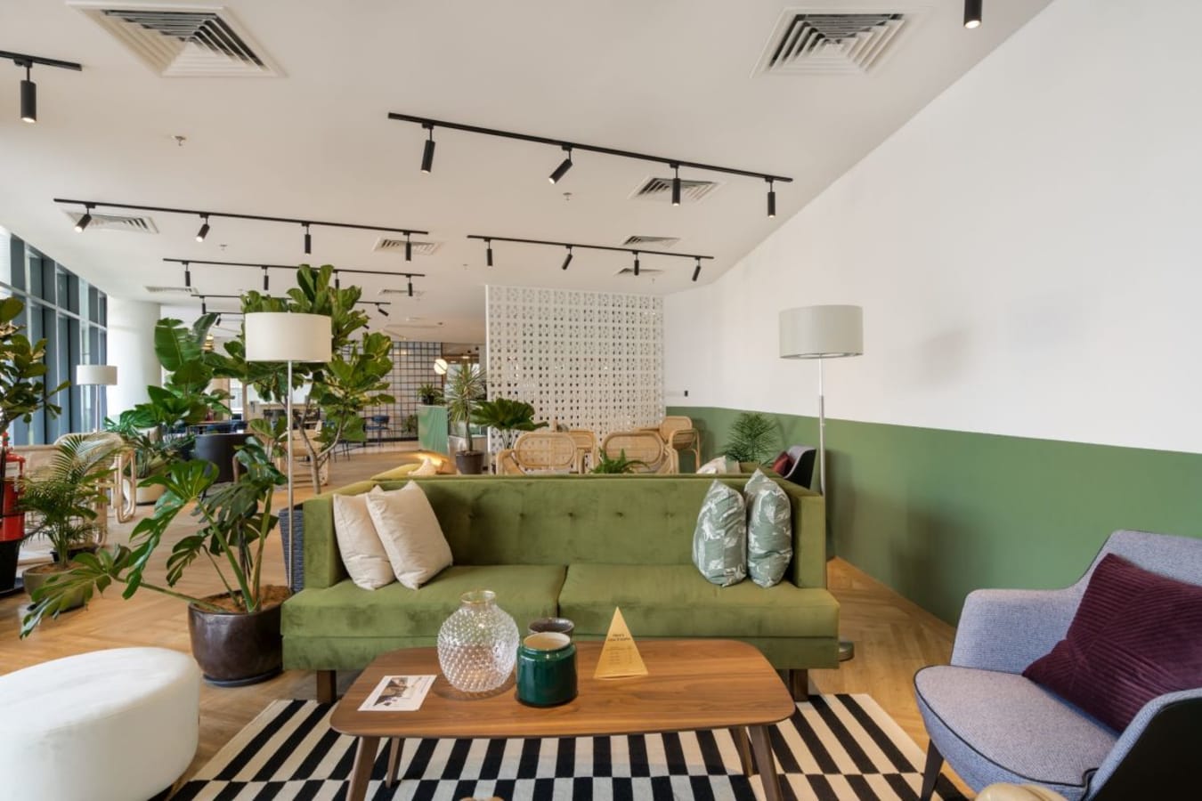 Vibrant coworking space with cozy seating, lush greenery, and ample natural light. Perfect for creativity.