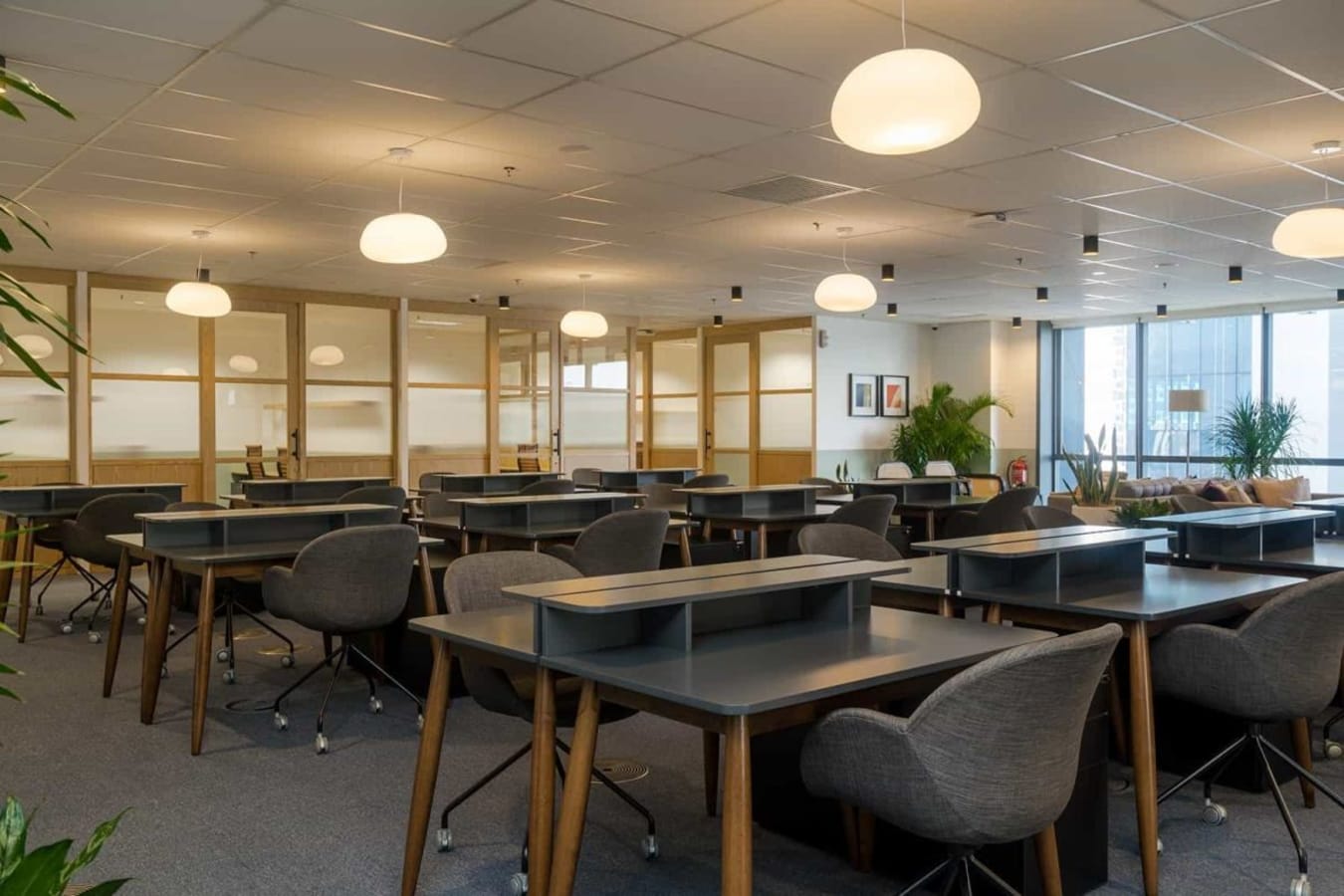 Modern coworking space with ample lighting, ergonomic seating, and collaborative ambiance.