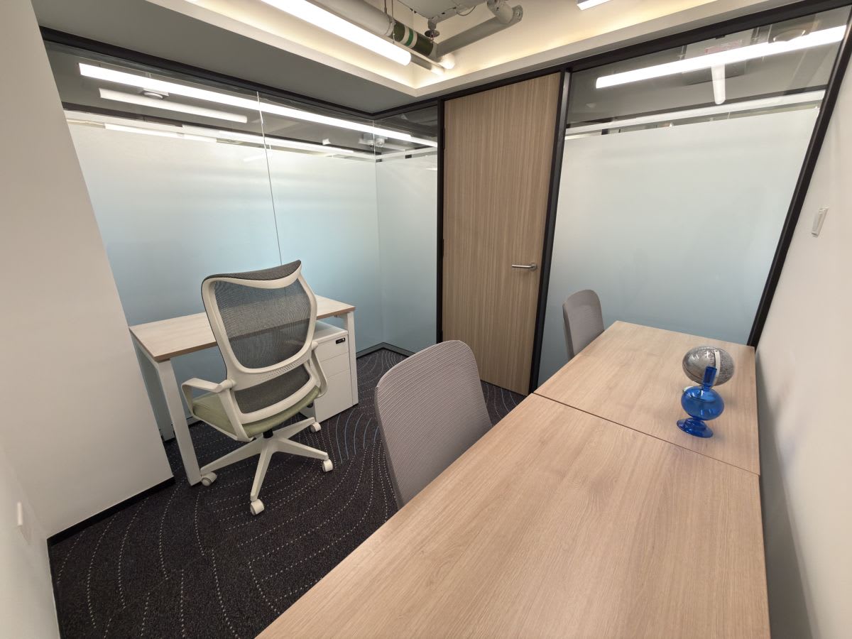 Modern coworking space with ergonomic chairs and sleek glass partitions on Connaught Road Central.