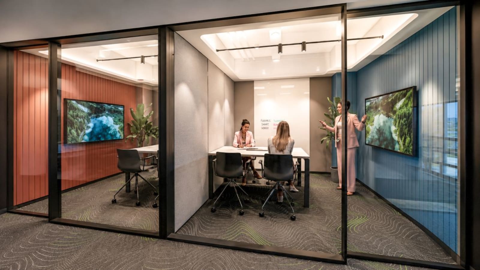 Modern meeting room with multimedia screens, sleek furnishings, and vibrant accent walls.