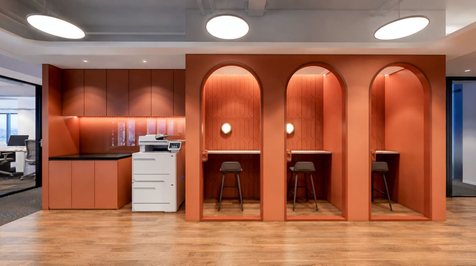 Elegant coworking booths with chic lighting and shared amenities on Connaught Road Central.