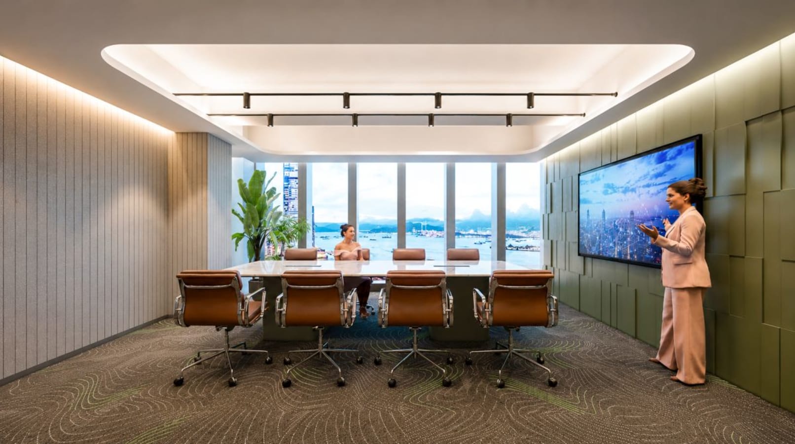 Sleek conference room with city views, modern seating, and large presentation screen.
