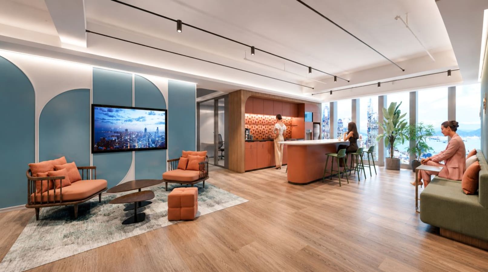 Stylish coworking lounge with modern seating, a kitchen area, and stunning views of Hong Kong.