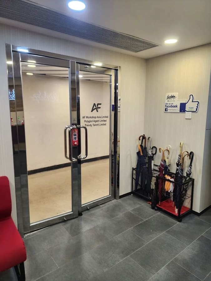 Welcoming entrance with sleek glass doors and convenient umbrella storage. Ideal for coworking.