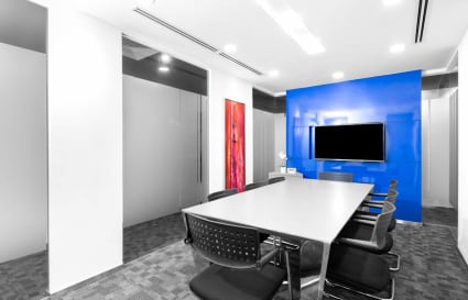 Modern conference room with sleek design, vibrant accents, and advanced technology setup.