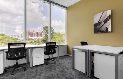 Bright coworking space with modern desks, ergonomic chairs, and a scenic city view.
