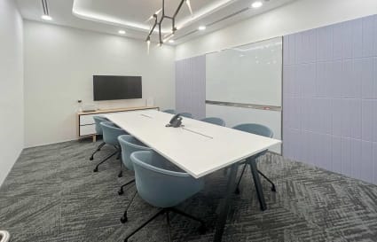 Modern conference room with a sleek table, ergonomic chairs, and a smart TV on Robinson Road.