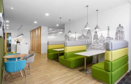 Modern coworking space with vibrant seating, ample natural light, and unique wall art in Raffles Place.