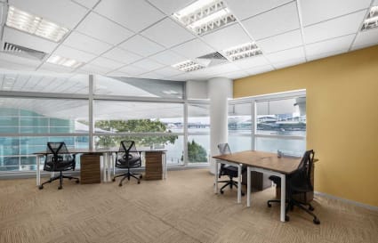 Bright coworking space with waterfront views, modern desks, and ergonomic chairs in Fullerton Road.