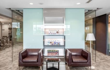 Modern coworking lounge with leather chairs, glass accents, and ambient lighting in Tampines Ave 5.