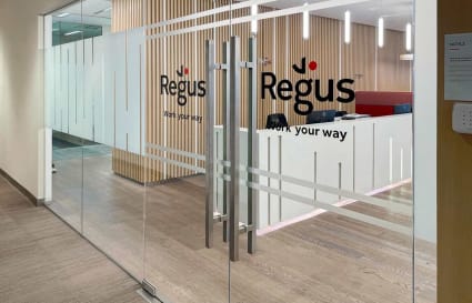 Modern coworking space with sleek glass entry, warm wooden accents, and inviting reception.