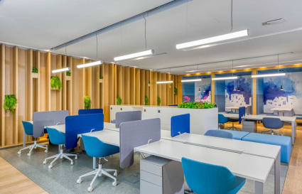 Modern coworking space with vibrant accents, ergonomic chairs, and ample natural light.