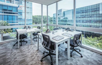 Bright corner workspace with modern desks, ergonomic chairs, and expansive views in Changi Business Park.