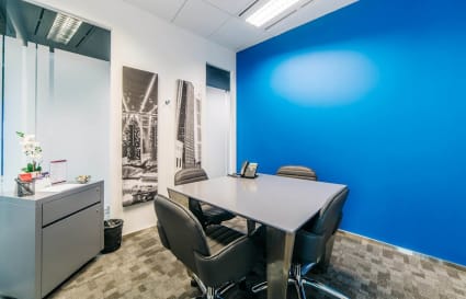 Modern coworking space with vibrant blue accent wall and sleek furnishings in Changi Business Park.