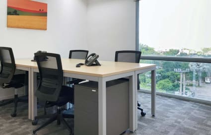 Bright coworking space with modern desks, ergonomic chairs, and a scenic window view.