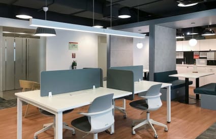 Modern coworking space with open seating, bright lighting, and a welcoming lounge area.