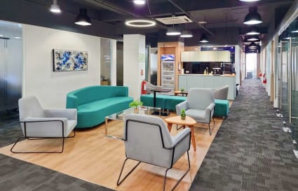 Modern coworking space with cozy seating, bright lighting, and a kitchenette on Jose Abad Santos Ave.