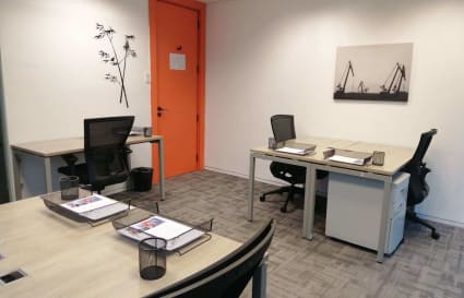 Modern coworking space with ergonomic chairs, ample desks, and vibrant decor. Ideal for productivity.