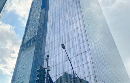 Modern high-rise office building with sleek glass facade, offering prime workspace location.