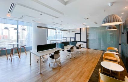 Modern coworking space with sleek desks, ergonomic chairs, and abundant natural light.