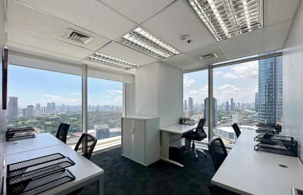 Bright office with expansive city views, modern desks, and ample natural light.