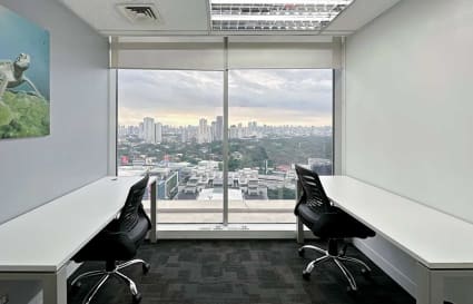 Bright office with cityscape views, modern desks, and ergonomic chairs. Ideal for productivity.