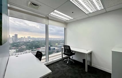 Bright office with stunning city views, modern desks, and ergonomic chairs for productivity.