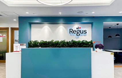 Modern reception area with sleek design, ample lighting, and inviting greenery. Ideal for professionals.