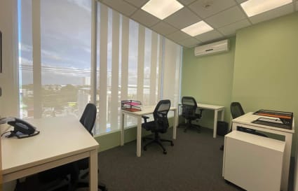 Bright office space with natural light, modern desks, and ergonomic chairs for productivity.