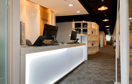 Modern reception area with sleek lighting and ample workspace, ideal for welcoming clients.