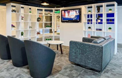 Modern lounge area with sleek chairs, a cozy sofa, and a decorative shelving backdrop.