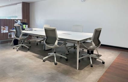 Modern workspace with ergonomic chairs and a spacious meeting table. Ideal for collaboration.