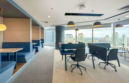 Modern coworking space with city views, cozy booths, and ample natural light.