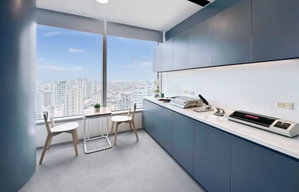 Modern office with skyline views, sleek cabinetry, and a cozy seating area.