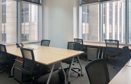 Modern office with large windows, ergonomic chairs, and ample desk space. Ideal for productivity.