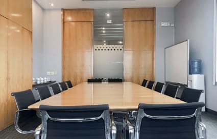 Sleek conference room with modern seating and ample natural light. Ideal for meetings.