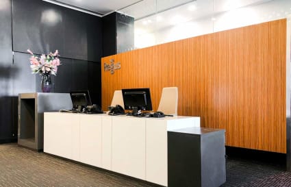 Modern reception area with sleek design, ample lighting, and elegant floral arrangement.
