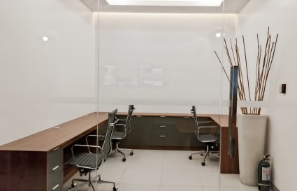 Modern office with sleek desks, ergonomic chairs, and ambient lighting. Ideal for focused work.