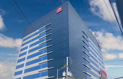 Modern high-rise office building with sleek glass facade and ample natural light. Perfect for businesses seeking a contemporary space.