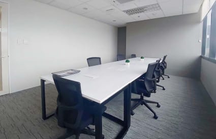Spacious meeting room with modern furnishings and ample natural light. Ideal for team collaboration.