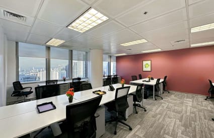 Modern office with ample natural light, city views, and collaborative workspace.