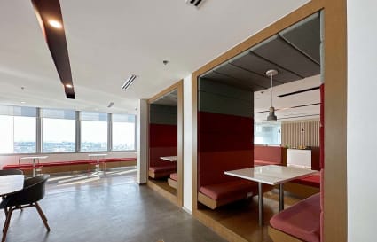 Modern coworking space with stylish booths, ample seating, and stunning city views.