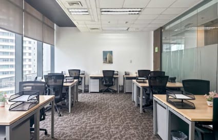 Modern workspace with ample natural light, sleek desks, and ergonomic chairs. Ideal for productivity.