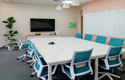 Modern conference room with stylish chairs, ample seating, and advanced AV setup. Ideal for collaboration.