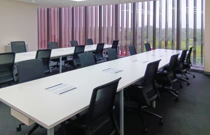 Modern open-plan office with ample natural light and sleek, ergonomic seating.