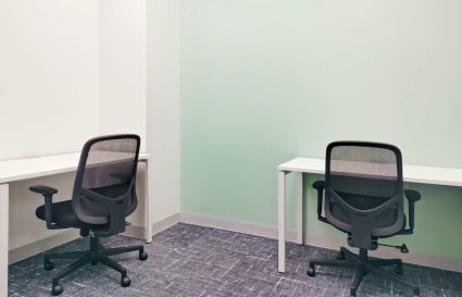Compact office with two workstations, ergonomic chairs, and a modern, minimalist design.