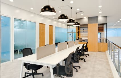 Bright coworking space featuring modern desks, ergonomic chairs, and stylish lighting.
